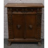 A carved mahogany side cabinet raised on claw feet, with key.