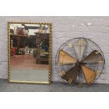 A gilt framed mirror, along with a wirework fan design wall clock 63cm diameter.