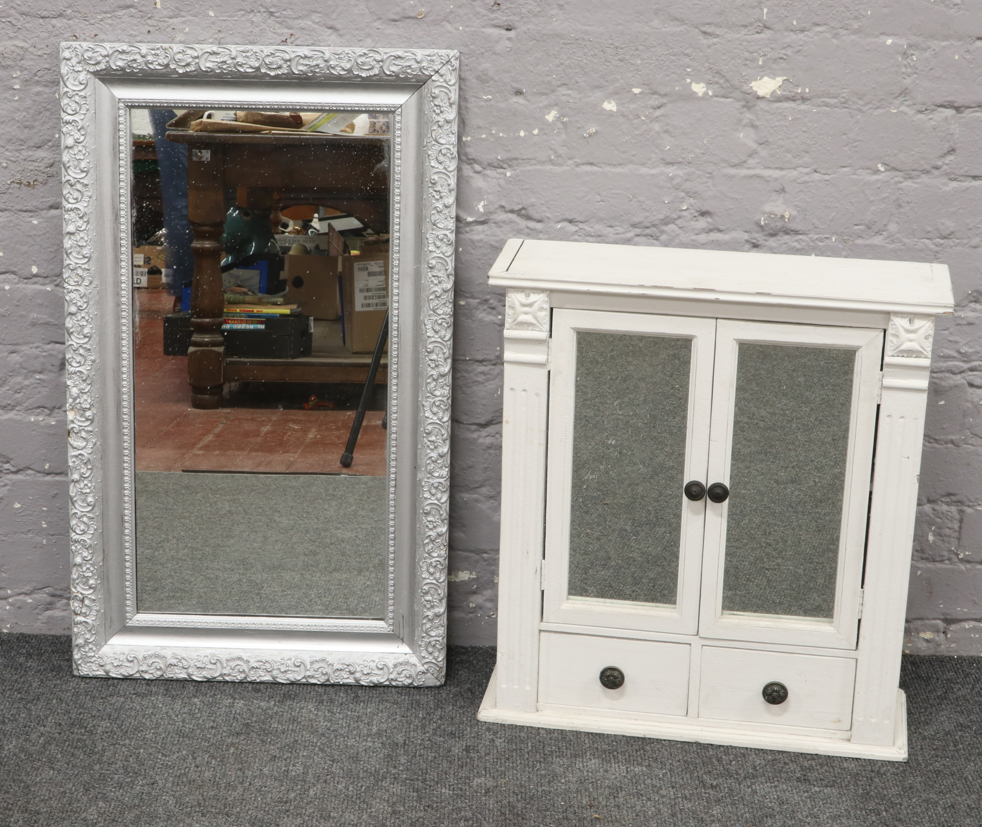 A white painted mirror front bathroom cabinet, along with an ornate bevel edge wall mirror.