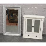 A white painted mirror front bathroom cabinet, along with an ornate bevel edge wall mirror.