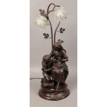 A bronzed composite twin branch figural table lamp formed as mother and child, marked Confidence.