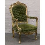 An ornate giltwood and green upholstered arm chair.