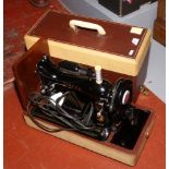 A cased Singer electric sewing machine.