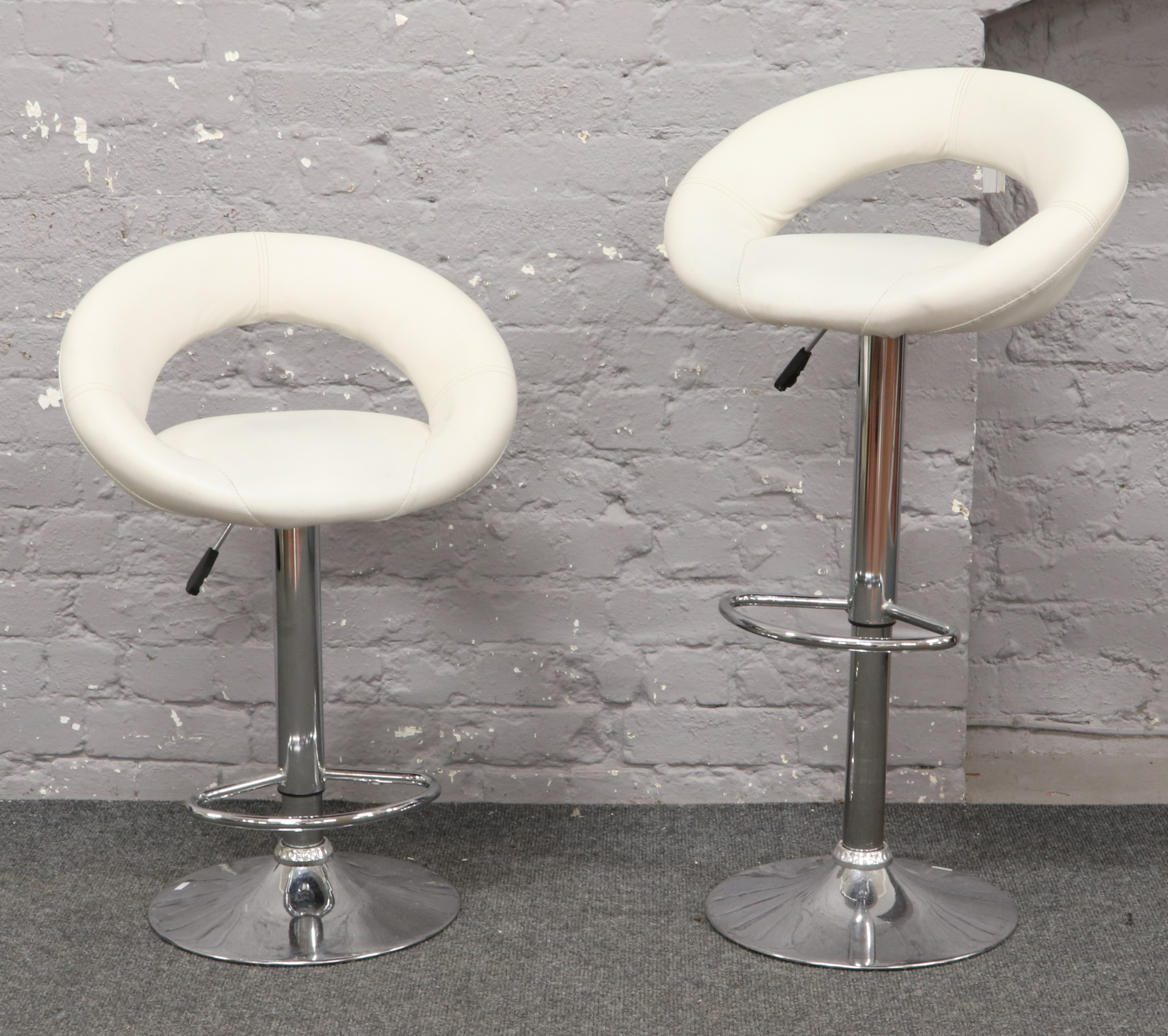 A pair of chrome and leatherette kitchen bar stools.