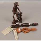 A pair of Welsh wooden love spoons along with a wooden carved African fisherman figure.