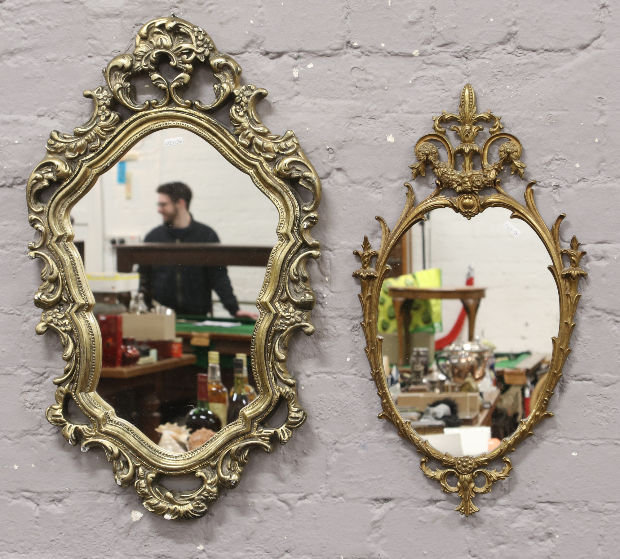 Two ornate gilt framed wall mirrors.