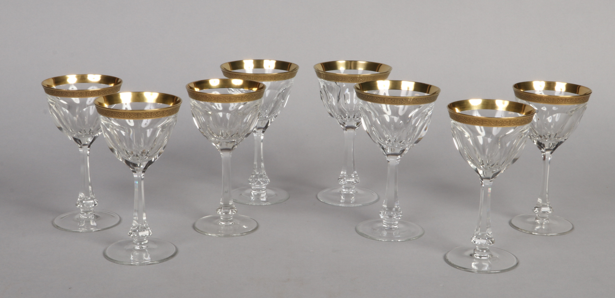 A set of eight Moser red wine glasses in the Lady Hamilton pattern. With etched gold borders and