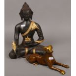 A metal seated Buddha statue along with another bronze of a recumbent dog.