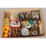 A box of various costume jewellery including faux amber beads.