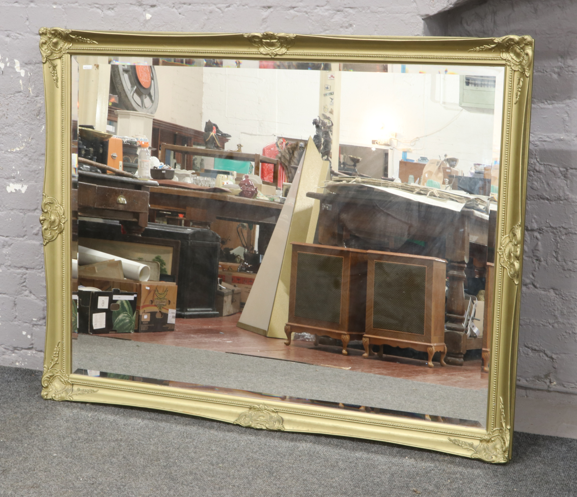 A large gilt framed bevel edge wall mirror, 136cm x 105cm.