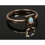A 9ct gold gypsy set opal ring with stepped shoulders, size L.