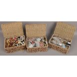 Three baskets of mixed costume jewellery beads, bangles etc.