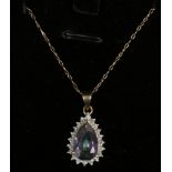 A 9ct gold mounted mystic topaz and diamond pear formed pendant on chain.