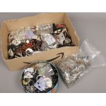 A box and a tin of costume jewellery to include bangles, beads, earrings along with a bag of chains.