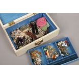 A fitted jewellery box and assorted costume jewellery including simulated pearls and enameled pieces