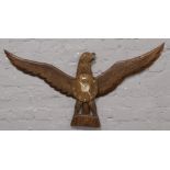 A carved hardwood eagle wall clock with quartz movement.