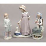 Three Lladro figures to include large girl with doll example.