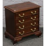 A mahogany chest of four drawers with brass handles.