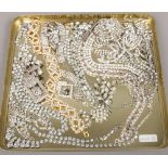 A tin of assorted white paste costume jewellery including Art Deco clip, spray brooch and