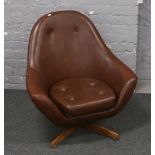 A 1970s leather swivel armchair.