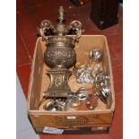 A box of metalwares to include four cast metal ball and claw bath feet and an ornate table lamp.