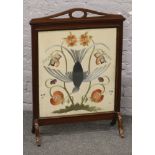 A mahogany framed fire screen with embroidered glazed panel.