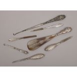 A collection of silver handled manicure tools, button hooks and a shoe horn.