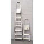 Two sets of aluminium step ladders.