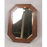 A carved oak framed octagonal bevel edge wall mirror.