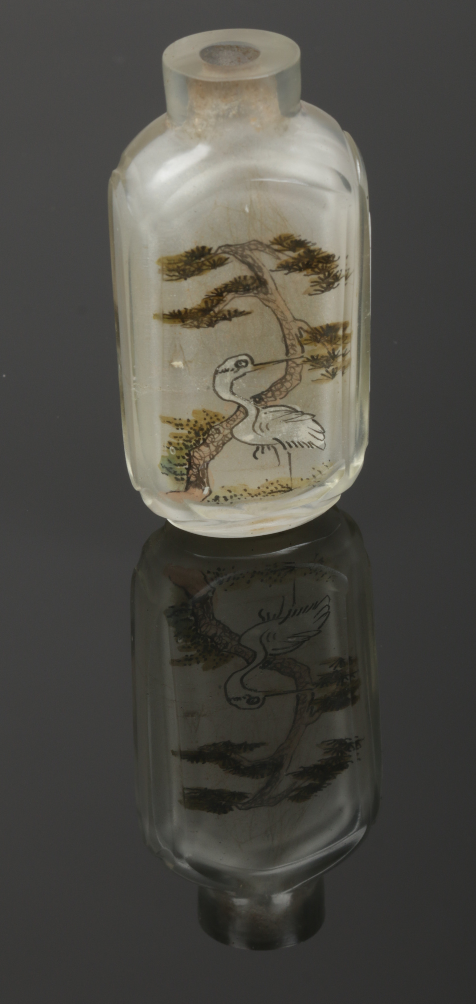 A Chinese glass scent bottle with cut mouldings. Painted inside out with a crane under a pine tree