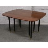A G plan retro teak drop leaf table raised on eight black painted brass foot legs, 130cm x 106cm (