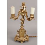 A French gilt bronze three branch tablelamp. With leaf moulded sconces and raised on a column plinth