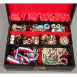 A cantilever jewellery box and assorted costume jewellery including clip on earrings, pearls and