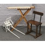 A child's ironing board, chair and pull along cart.