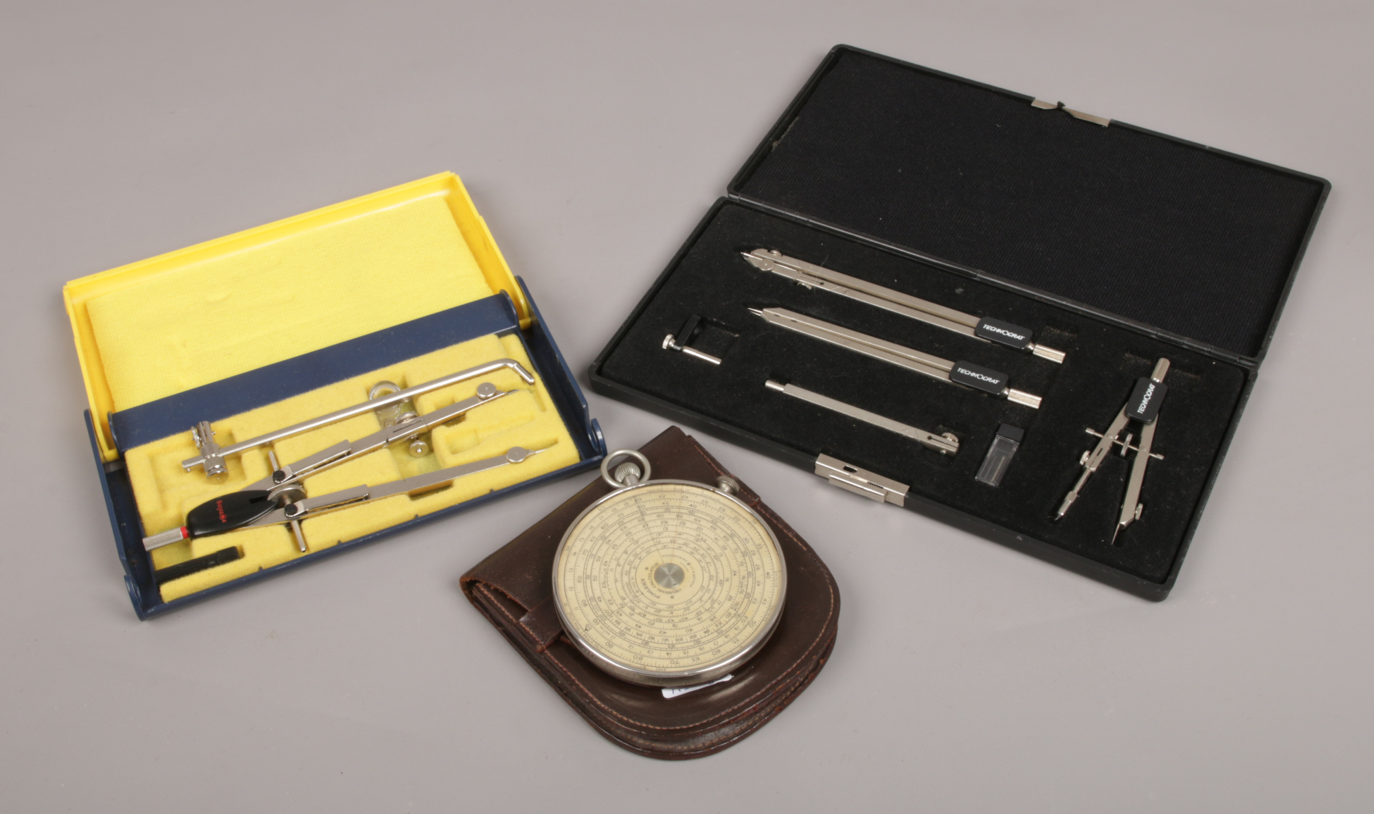 A Fowler's Universal calculator in leather case, along with two cased sets of drawing instruments.