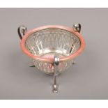 An early 20th century white metal openwork basket. With three double scrolling handles terminating