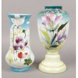 Two large hand painted opaline glass vases decorated with flowers.