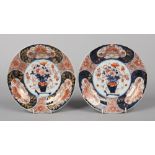 A pair of Japanese Edo period Imari dishes. Each decorated with a central urn of flowers under