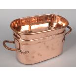 A 19th century French copper stew pan of elongated ovoid form and with wrought handles, 46cm wide,