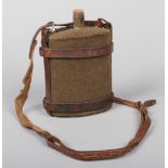 A World War I Officers enameled water bottle with cork stopper. Canvas clad and with leather