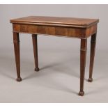 A George III mahogany fold over tea table. Raised on square tapering supports terminating on block