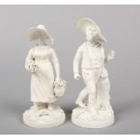 A pair of Rockingham biscuit figures, Swiss Boy and Girl raised on round bases. The girl with