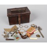 A World War I leather Howitzer sight case containing personal effects. Including, pipes, spectacles,