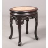 An early 20th century Chinese hardwood jardiniere stand with marble inset top, 52cm.