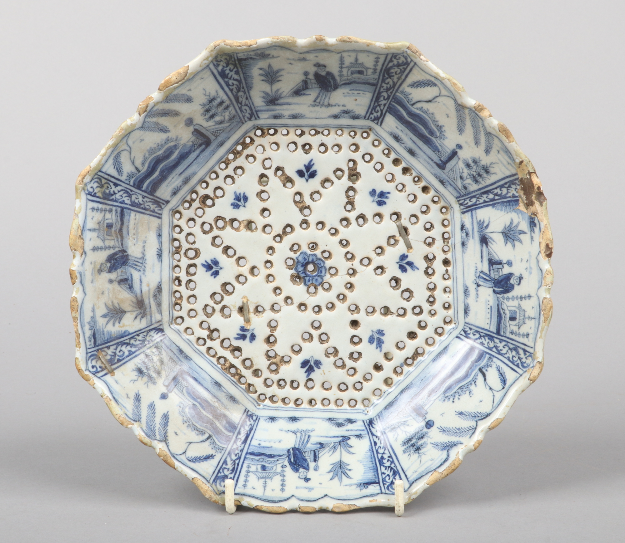 A 19th century Dutch delft blue and white cress drainer of scalloped octagonal form. Painted with