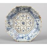 A 19th century Dutch delft blue and white cress drainer of scalloped octagonal form. Painted with