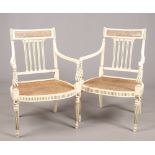 A pair of Regency style painted canework armchairs raised on reeded tapering supports.