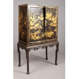 An early 19th century Chinese black lacquer cabinet on table stand. Embellished to the doors and