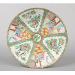 A 19th century Cantonese charger. Decorated with panels of figures and flowers, 40.75cm diameter.