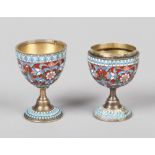 A pair of Russian enamelled silver pedestal egg cups. Red ground and decorated in pale blue,